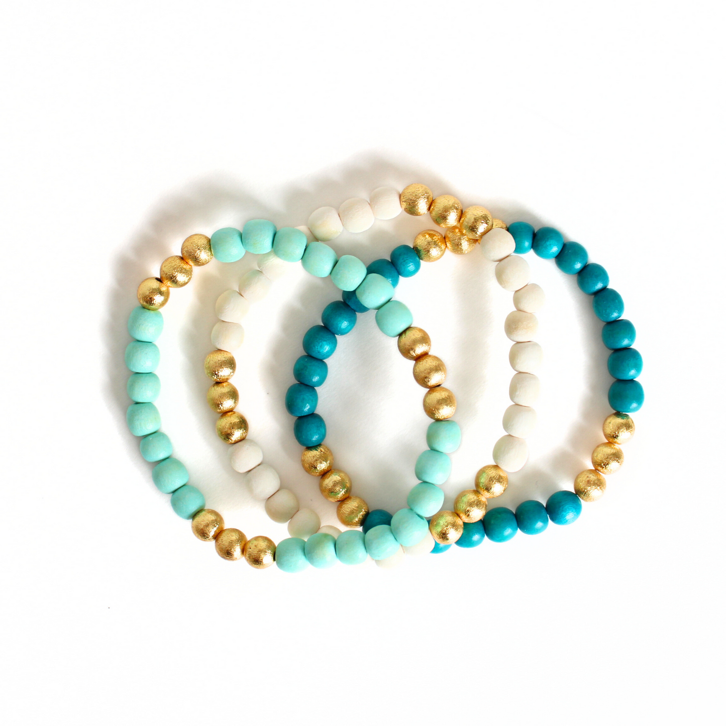 3-peice turquoise, mint and white lightweight wood stretch beaded bracelet set. All three bracelets accented with brushed gold beads.