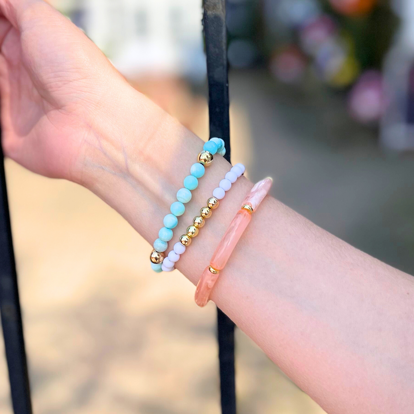 Model wearing 3-peice beach inspired stack. Designed with peach marble 8mm skinny acrylic bamboo tubes with gold plated flats. This stack also is designed with 8mm blue opal beaded bracelet with gold filled beads and a 5mm gold filled beaded bracelet accented with white round acrylic beads.