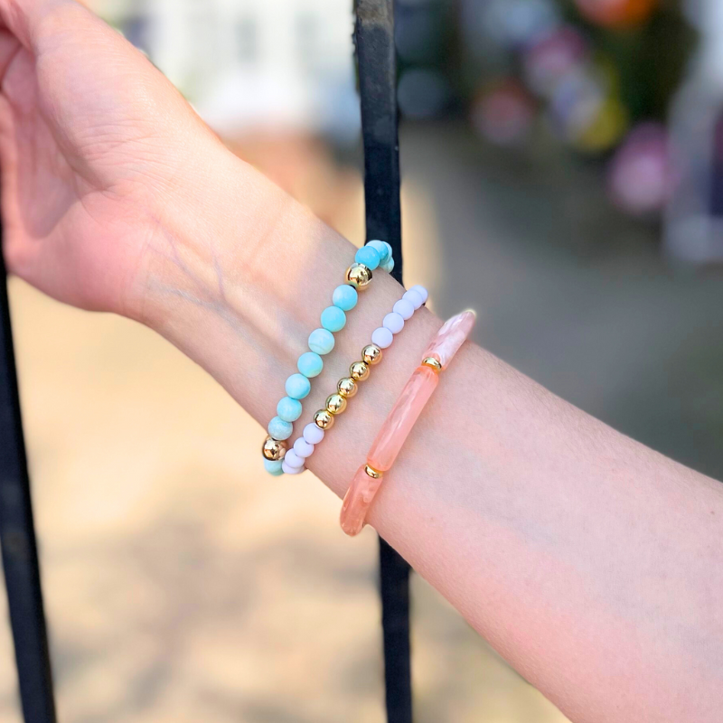3-piece blue opal gemstone bracelet stack styled with peach marble acrylic bangle and a white acrylic beaded bracelet with gold-filled round beads