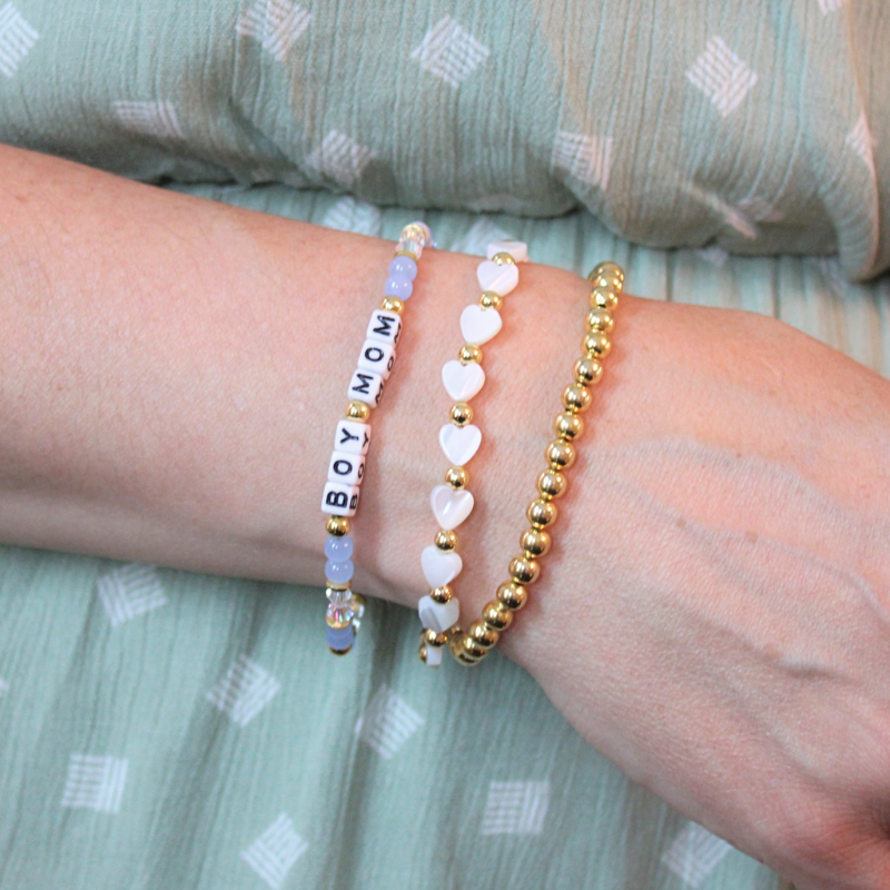 Blue boy mom bracelet set with mother of pearl heart charms and gold beads.