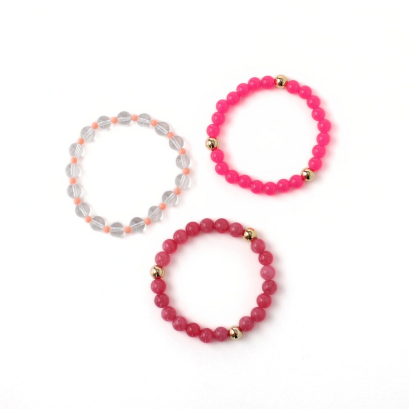 5-piece pink beaded bracelet stack. Designed with bright pink acrylic round beads accented with gold filled round beads. Clear quartz round beaded bracelet is adorned with 4mm peach acrylic beads.