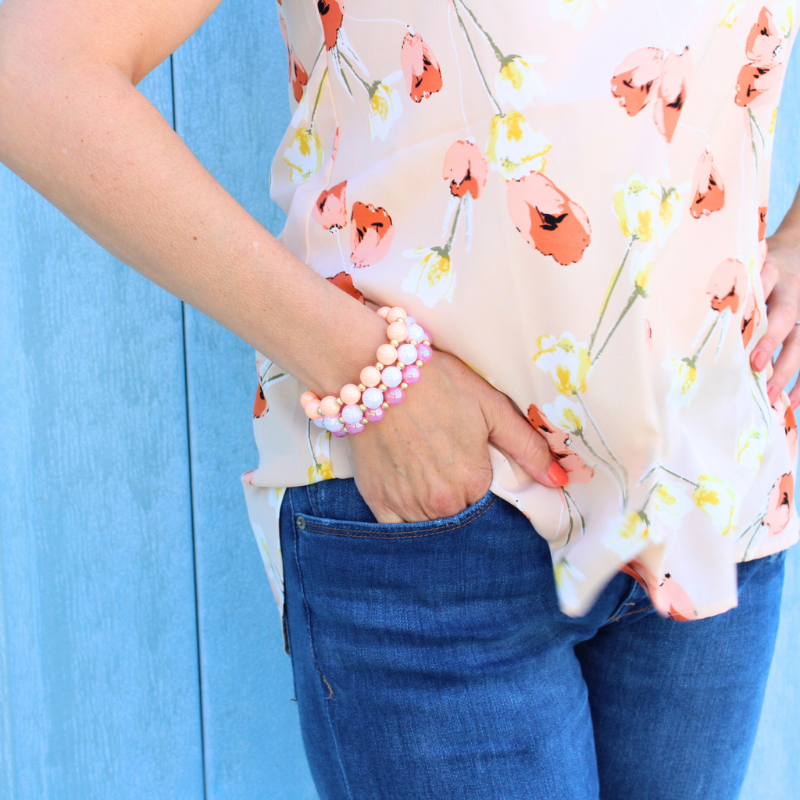 Model wearing 3-piece chunky acrylic beaded bracelet set. Designed with 12mm pink, white and peach iridescent acrylic beads. Between each acrylic bead is a 5mm 18k gold filled round beads.