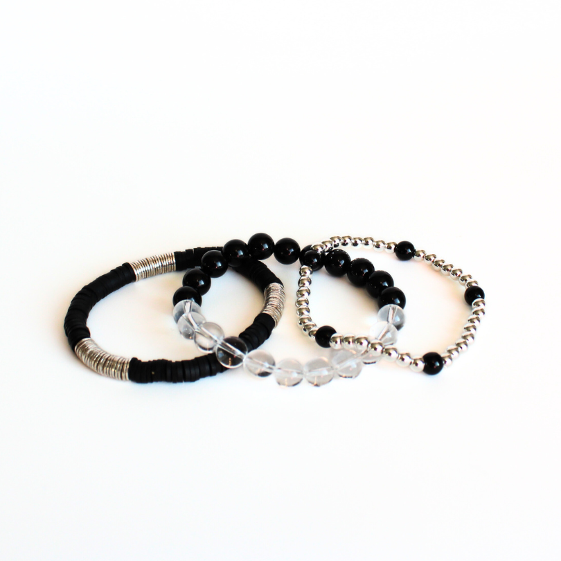 Black and silver beaded bracelet set curated with silver round beads, black onyz gemstones, clear quartz gemstone and black polymer clay beads.