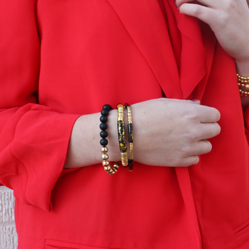 This 3-piece black beaded stretch bracelet set is the perfect statement piece. With its classic colors, this bracelet set is designed with 18K gold filled beads, white crackled beads, and black acrylic bangles.