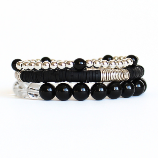 Black and silver beaded bracelet set curated with silver round beads, black onyz gemstones, clear quartz gemstone and black polymer clay beads.