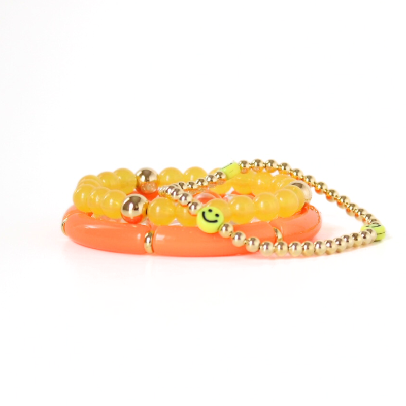3-piece bright orange and yellow acrylic ang gold-filled beaded bracelet stack. This set also is adorned with a dainty gold beaded bracelet with smiley face beads.