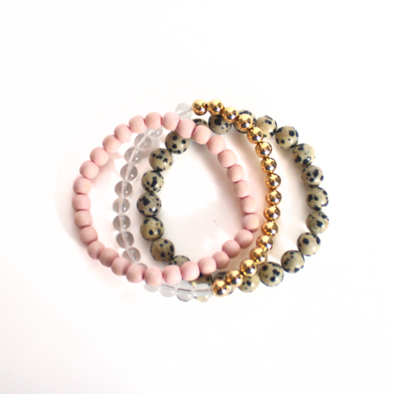 This neutral warm 3-peice set has soft features that go with any outfit. Curated with pink round wooden beads, gold filled beads, clear quartz beads and jasper gemstone beads.