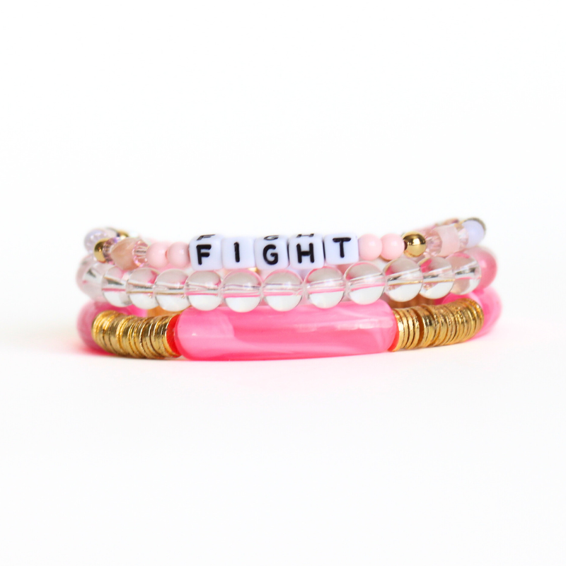 Pink beaded breast cancer awareness bracelet set. This very pink 3-piece bracelet set is curated with pink acrylic bangle, clear round quartz beads, pink beads and word beaded bracelet. Proceeds will be donated to the Susan G. Komen Foundation.