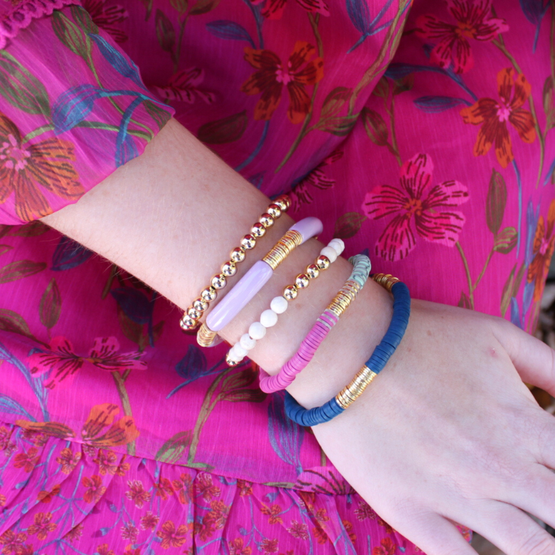 This 5-piece blue and purple beaded stretch bracelet set is the perfect statement piece. With its warm colors, it is designed with 18K gold filled beads and faceted natural coral river stone. Also designed with blue and purple polymer clay beads and a purple acrylic bangle.