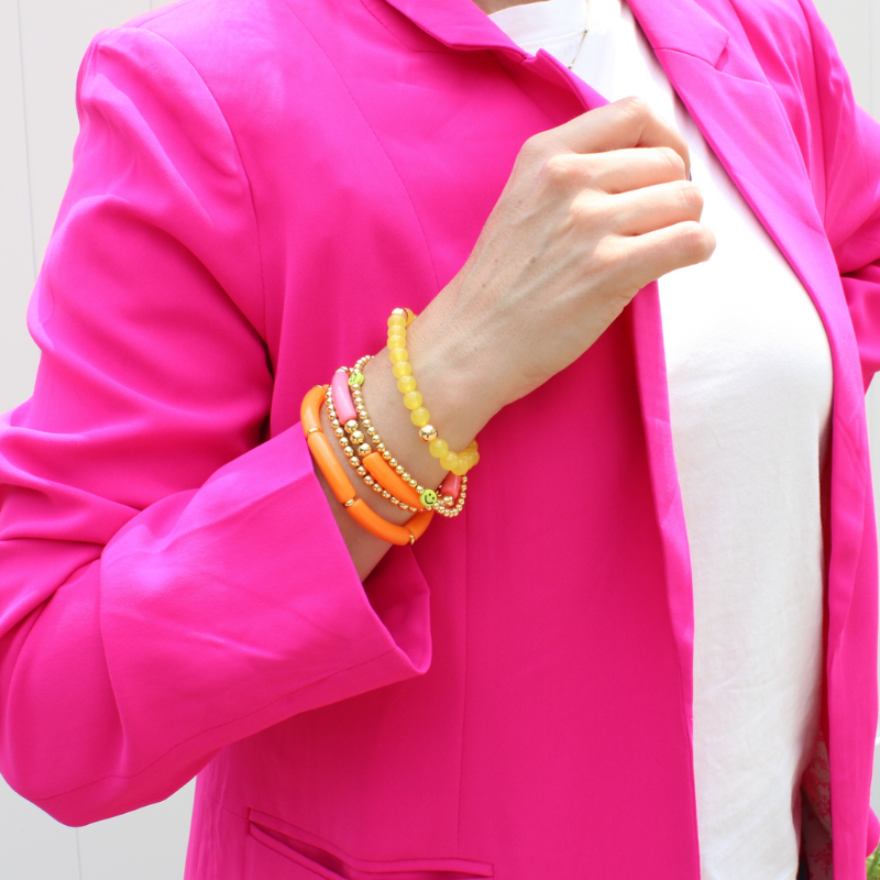 5-piece vibrant peach and yellow acrylic bracelet stack with 18k gold filled round beads. This set has a dainty gold beaded bracelet with cute yellow smiley face beads.