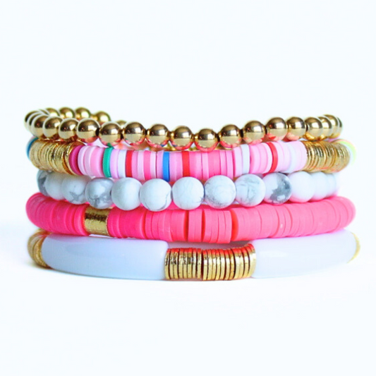 Bracelet set includes five bracelets. One 6mm gold filled beaded bracelet. One 6mm howlite beaded bracelet. One 6mm rainbow colored polymer clay and gold plated beaded bracelet. One white acrylic bangle bracelet with gold plated flat beads. One bright pink polymer clay bracelet with gold plated cylinder bracelet