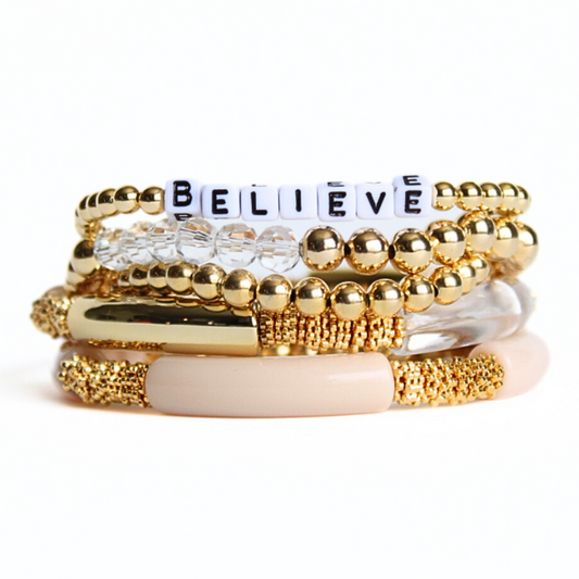 This 5-piece blue and white beaded stretch bracelet set is the perfect statement piece. With its bold neutral colors, it is designed with silver beads, clear glass beads and white howlite beads. The gray polymer clay beads are a playful addition