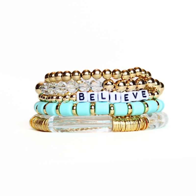 5-Piece 18K gold beaded stretch bracelet set with green polymer clay beads. This bracelet stack has all of the glamour and glitz to complete that perfect outfit. Also designed with white acrylic bangles and white acrylic cubed letter beads which can be personalized.