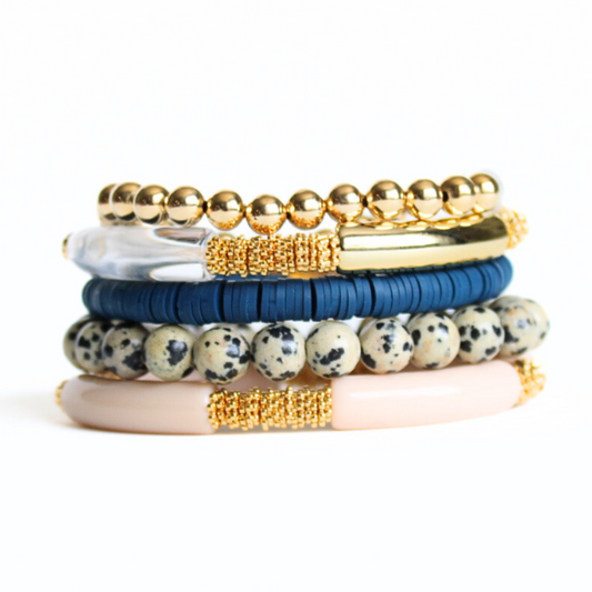 This 5-piece pink beaded stretch bracelet set is the perfect statement piece. With its neutral color palate, it is designed with 18k gold filled beads, clear glass beads and gold and gray bangles. The pink and gray rainbow polymer clay beads add that perfect pop of color.