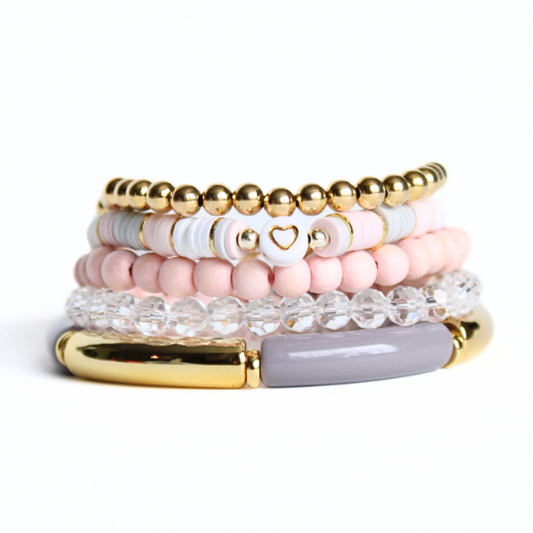 This 5-piece pink beaded stretch bracelet set is the perfect statement piece. With its neutral color palate, it is designed with 18k gold filled beads, clear glass beads and gold and gray bangles. The pink and gray rainbow polymer clay beads add that perfect pop of color.