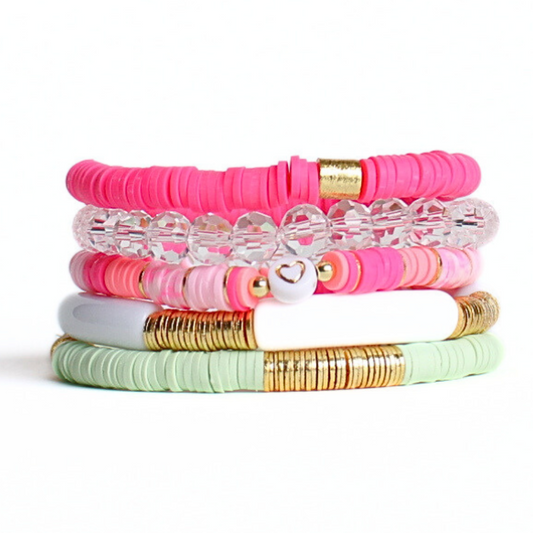 This 5-piece pink and green beaded stretch bracelet set is the perfect statement piece. With its bold and bright colors, it is designed with 18K gold filled beads, clear glass beads and a clear acrylic bangle. The pink rainbow polymer clay beads add that perfect pop of color.