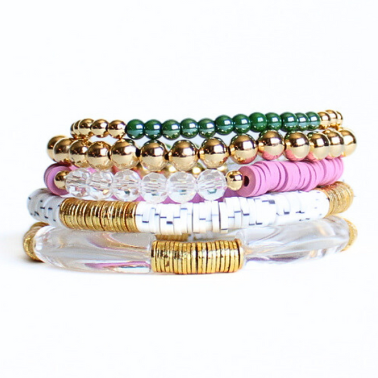This 5-piece pink beaded stretch bracelet set is the perfect statement piece. With its bold and bright colors, it is designed with 18k gold filled beads, clear and green glass beads and clear acrylic bangles. The white speckled and purple polymer clay beads add that perfect pop of color.