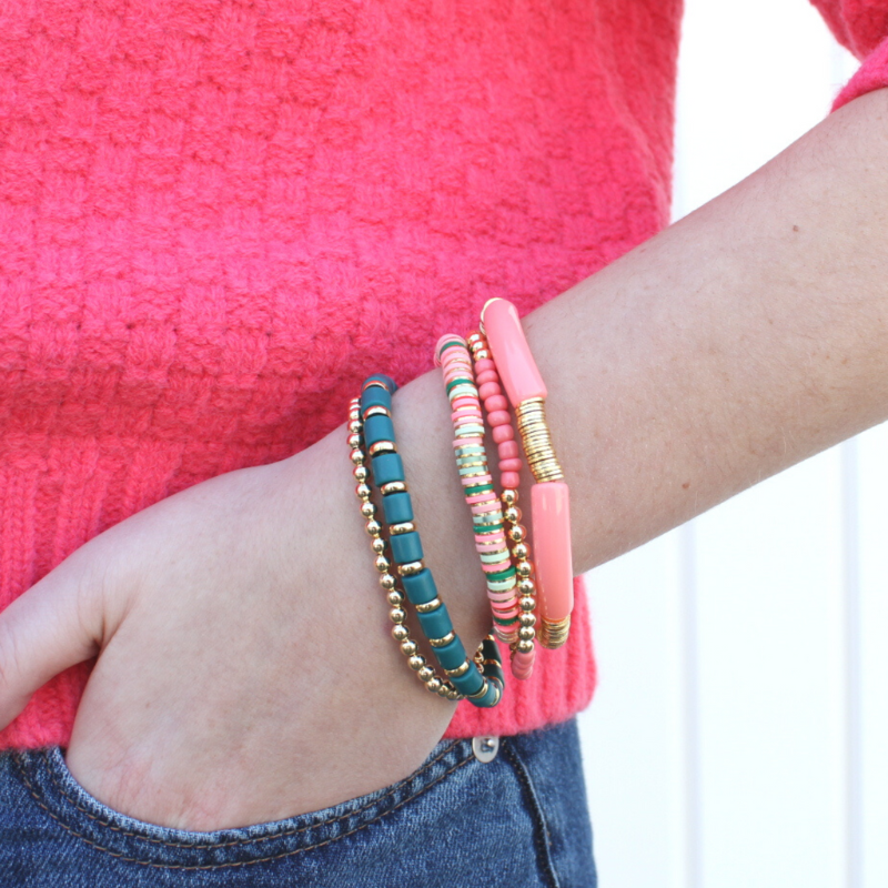 Girl model wearing five piece bracelet stack that features gold filled and gold plated beads- Pink and green colored beads give this set the name The Watermelon stack