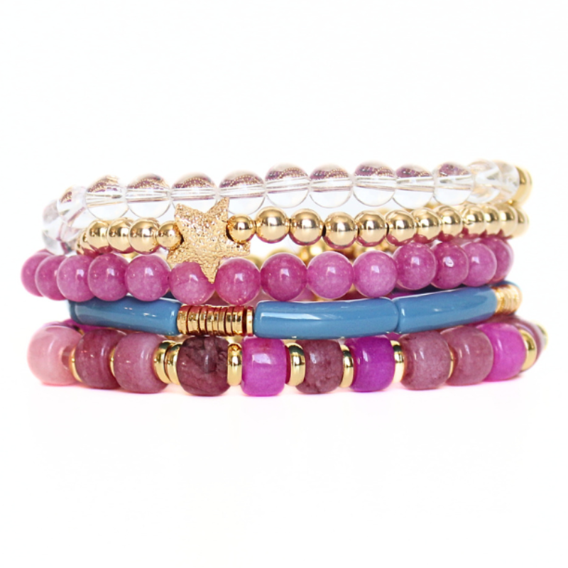 5-Piece purple beaded stretch bracelet set with 18k gold filled beads. The two gold beaded bracelets are designed with clear Brazilian quartz beads and a 14k gold forte charm. The two purple beaded bracelets are designed with forte gemstone beads and jade round beads. The skinny blue acrylic bangle adds the perfect touch.
