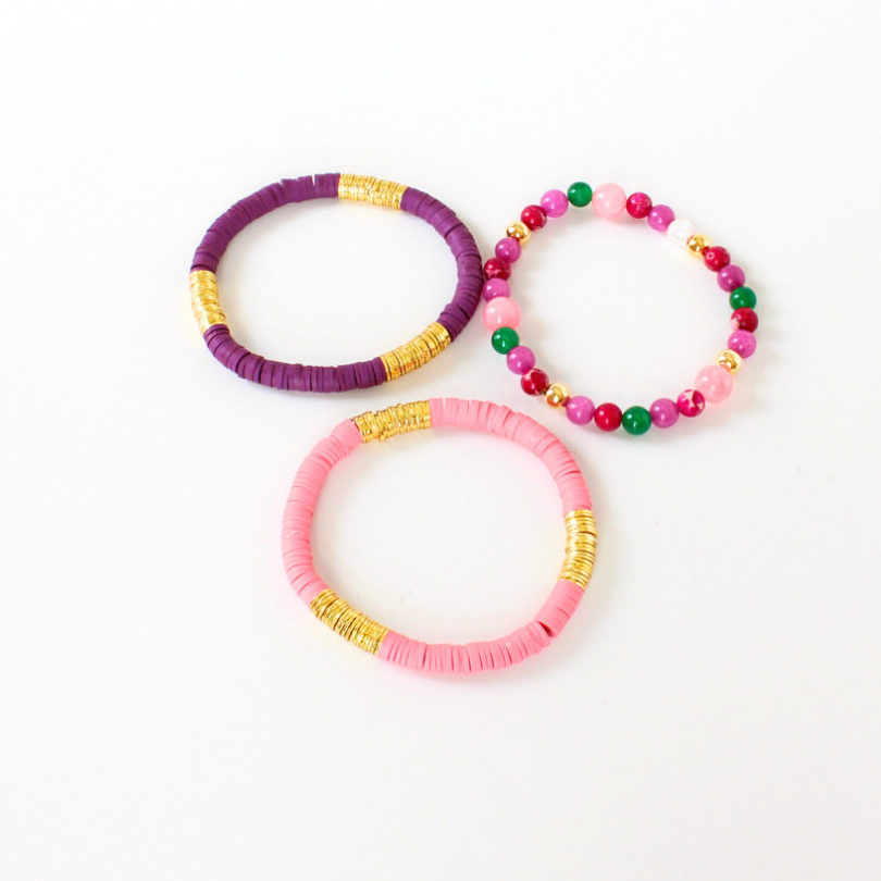 3-piece bracelet stack designed with pink and purple polymer clay beads accented with gold-plated flat beads. This bracelet stack is complimented with a pink, green and purple beaded bracelet designed with pink and purple jade beads and gold-filled beads