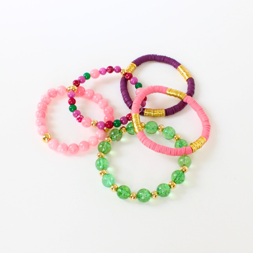 Pink, purple and green 5-piece bracelet stack. This stack is designed with polymer clay beads with gold-plated flats. Natural pink and white jade beads are adorned with gold-filed round beads complete this simple bracelet. The 12 mm gold round acrylic bead adds a modern touch to this gorgeous stack