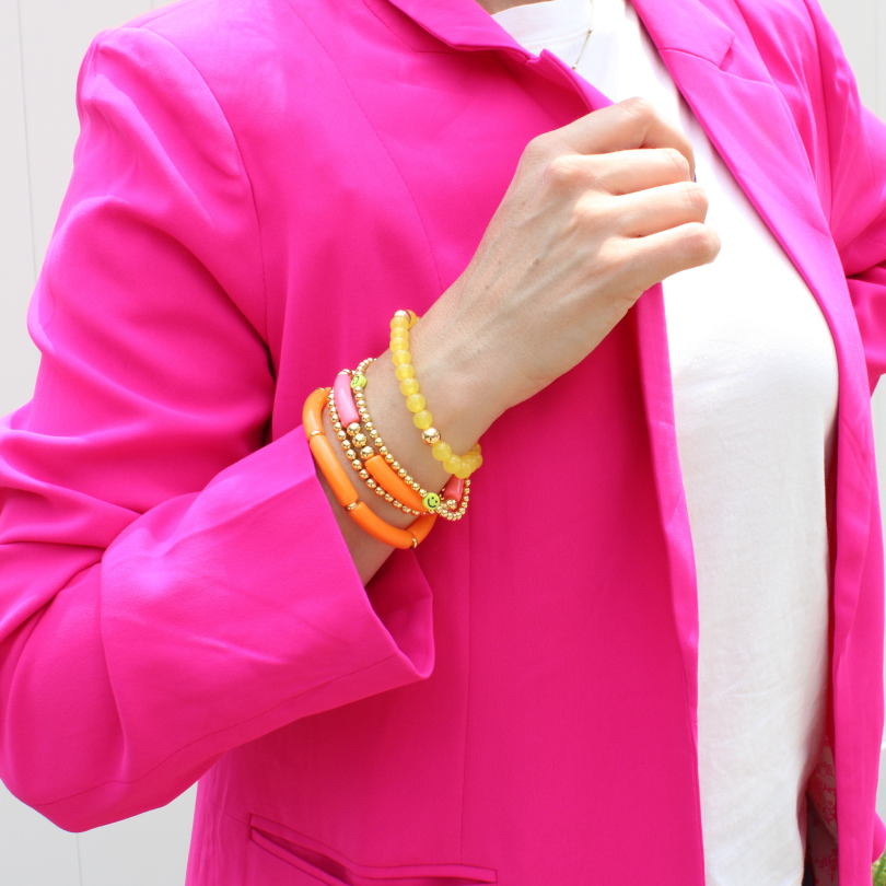 5-piece vibrant peach and yellow acrylic bracelet stack with 18k gold filled round beads. This set has a dainty gold beaded bracelet with cute yellow smiley face beads.