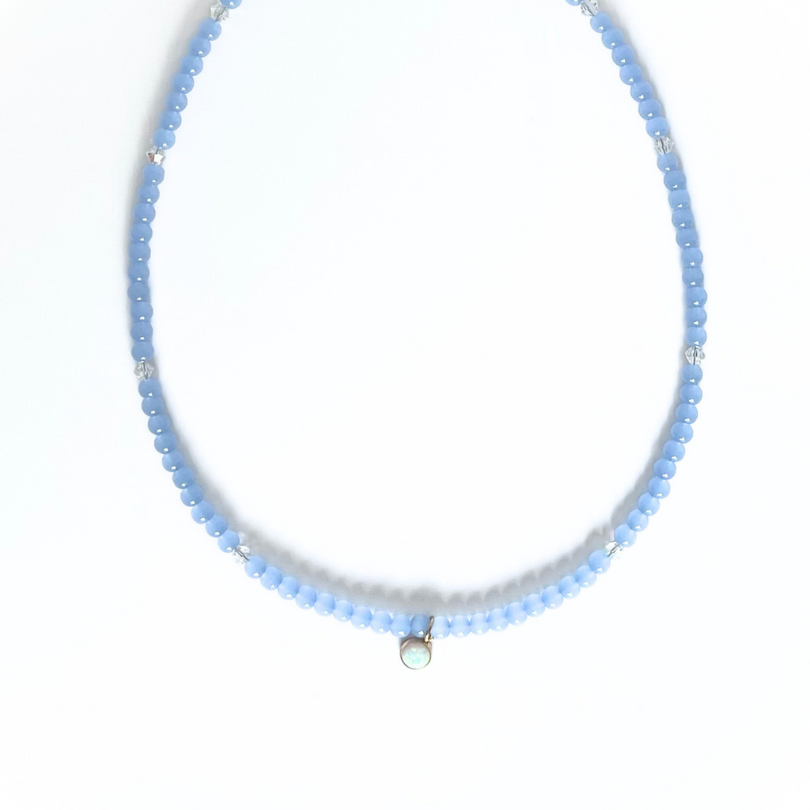 Blue glass beaded layering necklace with dainty round opal charm.