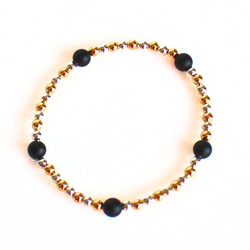 This delicate two-toned beaded bracelet is the perfect bracelet for everyday wear. With both gold filled and sterling silver tones, this bracelet can be worn with all of your bracelets. Also curated with black onyx gemstone beads.
