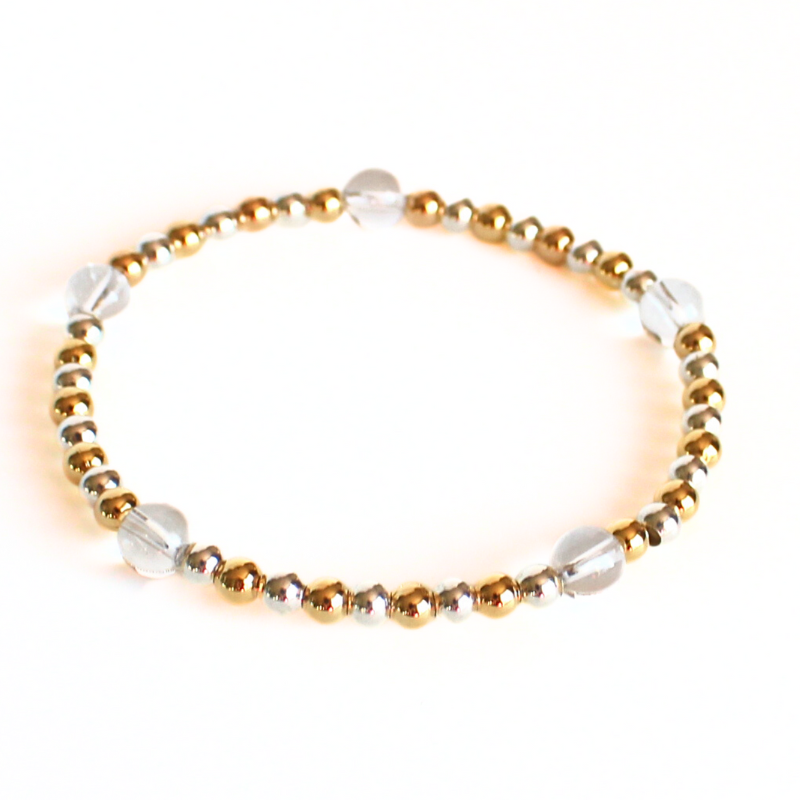 This delicate two-toned beaded bracelet is the perfect bracelet for everyday wear. With both gold filled and sterling silver tones, this bracelet can be worn with all of your bracelets. Also styled with clear quartz gemstone beads.
