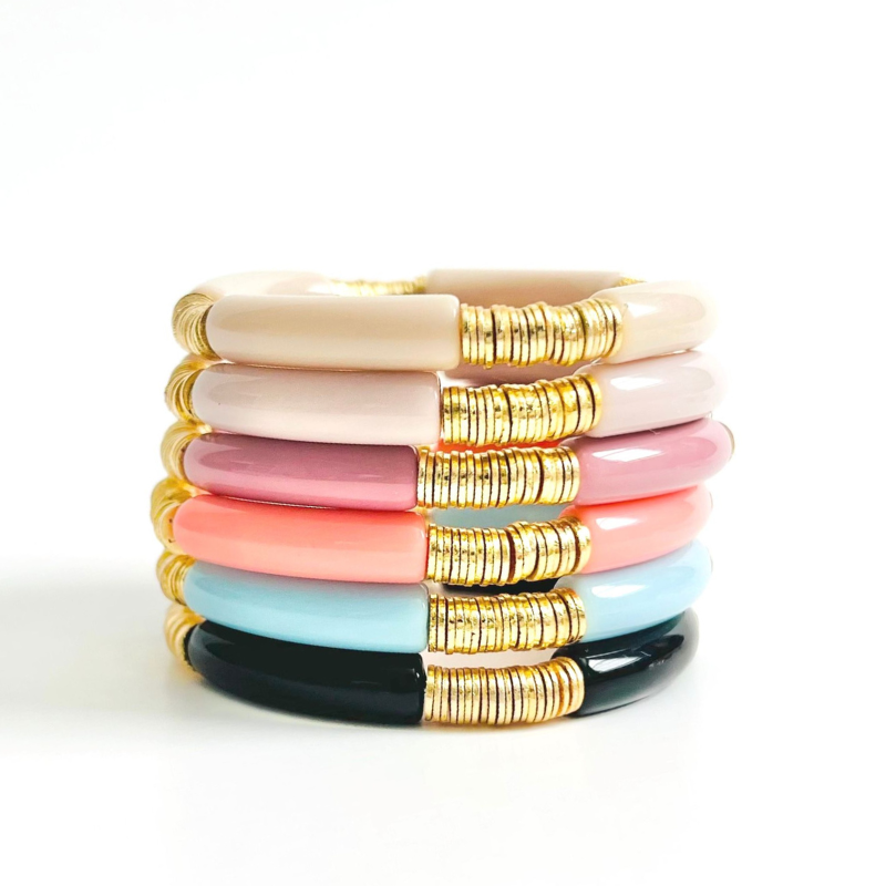 Stack of modern acrylic beaded bangles. These bracelets come in a variety of colors are designed with gold flat beads.