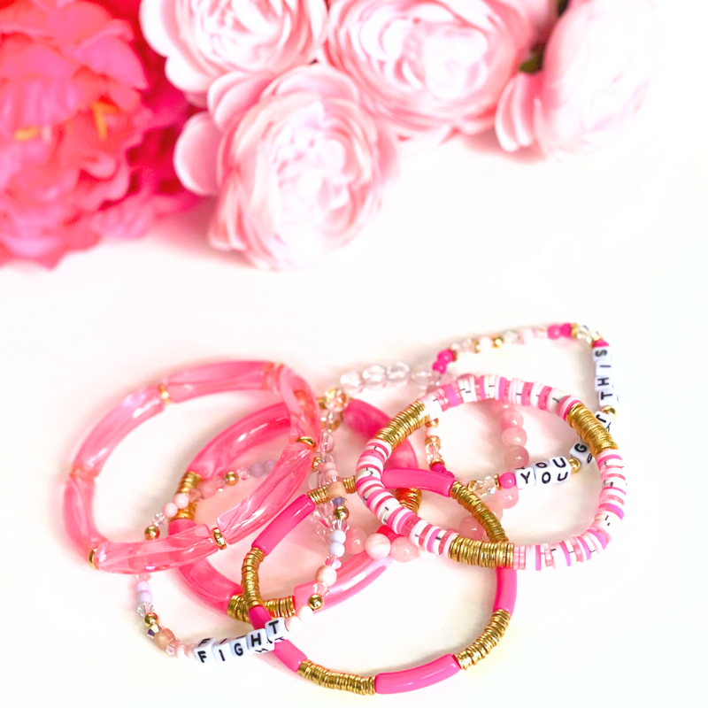 3-piece pink breast cancer bracelet stack. Designed with pink rainbow polymer clay beads, skinny acrylic tube beads and a dainty letter bead pink word bracelet.