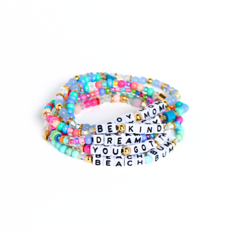 Dainty stretch word bracelet. Made with 5mm white with black letter cubed acrylic beads, 4mm blue and rainbows eed beads and green enamel cylinder beads. Letter beads can be personalized. Choose a name, initial or inspirational word to make it your own.