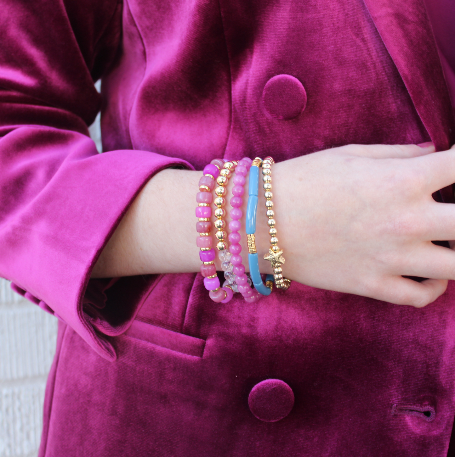 5-Piece purple beaded stretch bracelet set with 18k gold filled beads. The two gold beaded bracelets are designed with clear Brazilian quartz beads and a 14k gold forte charm. The two purple beaded bracelets are designed with forte gemstone beads and jade round beads. The skinny blue acrylic bangle adds the perfect touch.