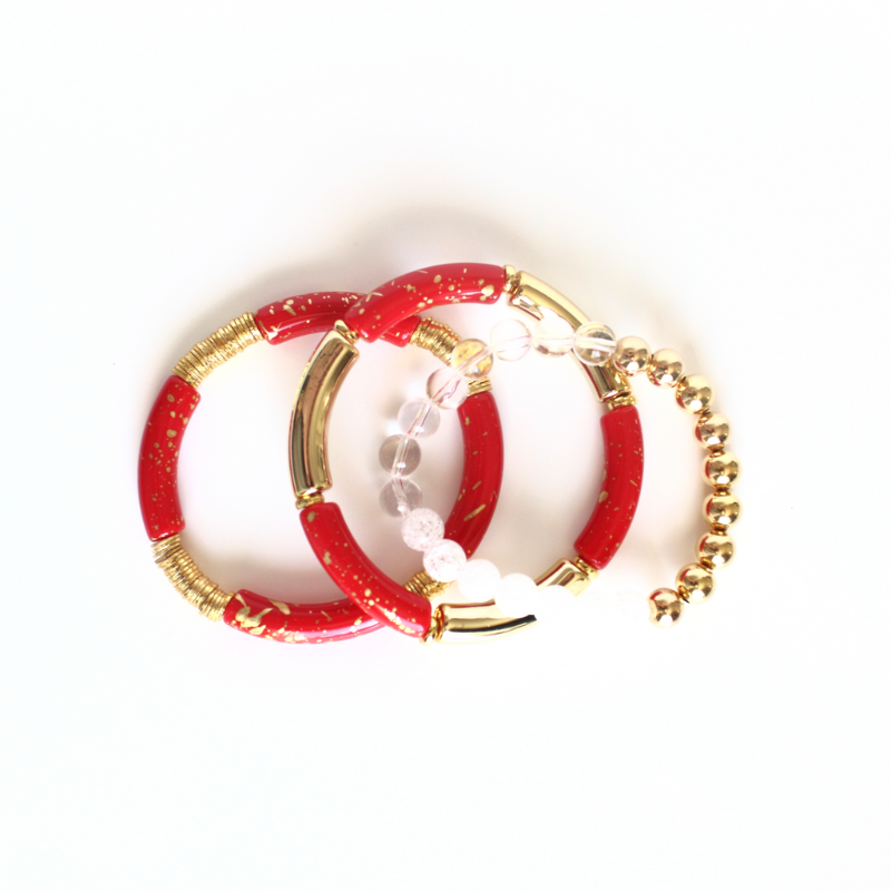 This 3-piece red beaded stretch bracelet set is the perfect statement piece. With its bold and bright colors, this bracelet set is designed with 18K gold filled beads, white crackled beads, and red and gold acrylic bangles.