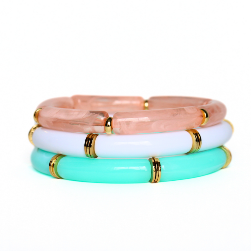 3-piece acrylic chunky bangle set. Each acrylic bracelet is designed with 8mm skinny acrylic tubes with gold plated flats alternating between each acrylic tube. This bracelet has aqua marble, peach marble and white acrylic tubes.