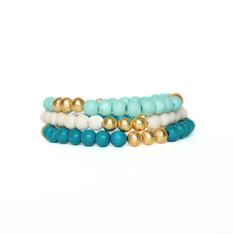 3-piece lightweight wooden beaded bracelet set with brushed gold accent beads. This 3-piece set includes a teal, mint and white wooden bracelet