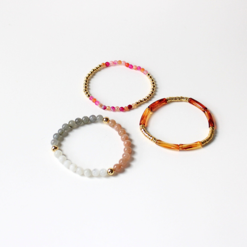 3-pece bracelet stack designed with chakra, moonstone and sunstone healing beads. Also designed with a dainty brown marble skinny acrylic bangle and a dainty gold-filled beaded bracelet with coral and magenta faceted agate beads.