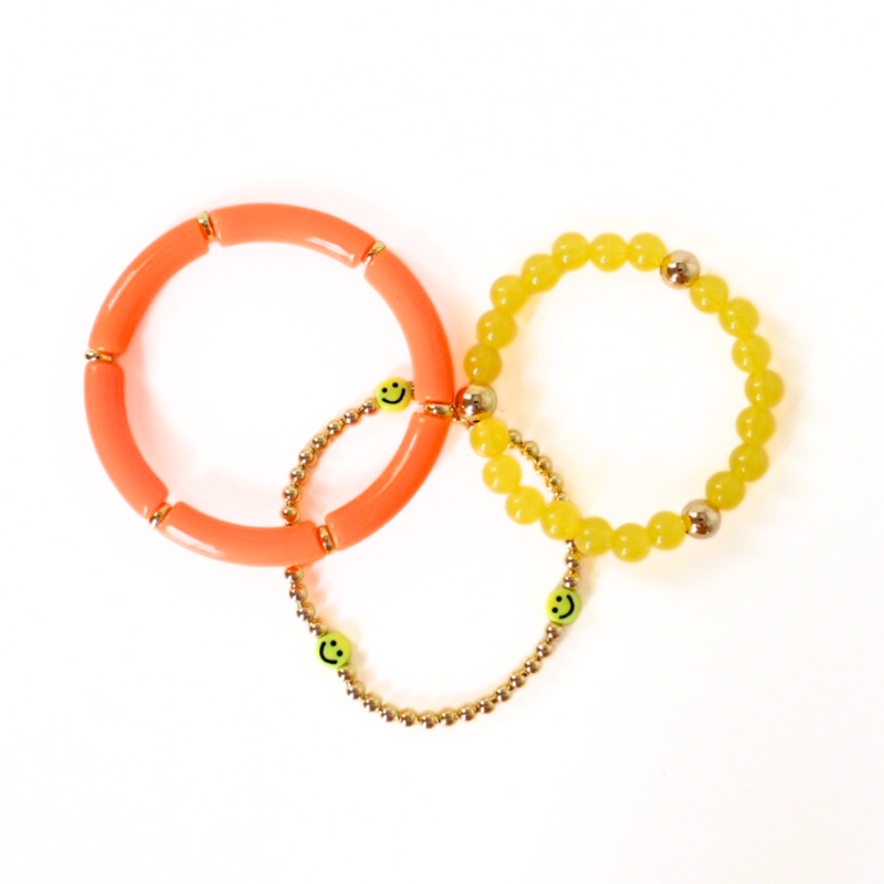 3-piece bright orange and yellow acrylic ang gold-filled beaded bracelet stack. This set also is adorned with a dainty gold beaded bracelet with smiley face beads.