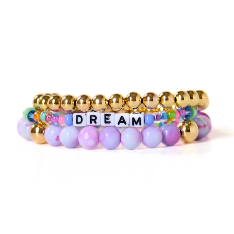 Set of 3 bracelets. Purple opal gemstones beaded bracelet is the star of this bracelet. This bracelet is designed with gold filled round beads and a dainty rainbow beaded white cubed letter beaded bracelet.