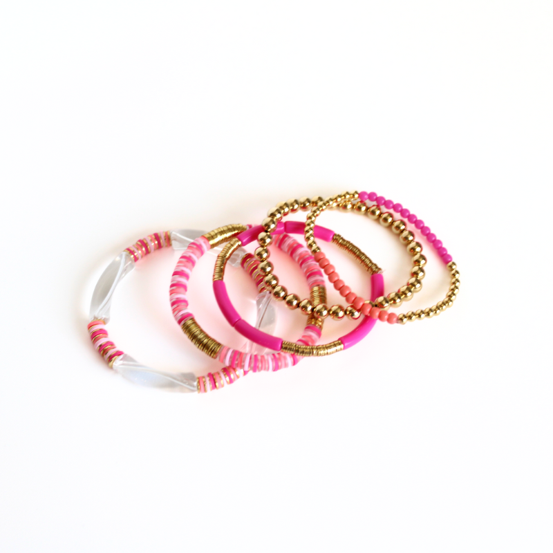 This 5-piece pink and orange beaded stretch bracelet set is the perfect statement piece. With its bold and bright colors, it is designed with 18K gold filled beads and orange glass beads. The pink and white acrylic bangle and the pink rainbow polymer clay beads add that perfect pop of color.