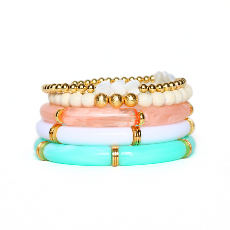 5-piece bracelet set. Designed with a peach marble, white and aqua marble 8mm acrylic bamboo tubed bangle. Each acrylic bangle has gold plated flats alternating between each acrylic tube. This bracelet stack is also designed with a lightweight wooden white beaded stretch bracelet with brushed gold beads and a dainty 4mm gold filled beaded bracelet accented with pearl hearts.