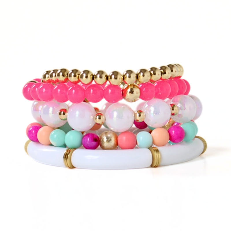 Set of 5 bracelets. The Santorini bracelet stack has white tubed and round iridescent acrylic beads. A bright pink acrylic beaded bracelet adds color and attitude. This bracelet has a stunning bracelet mixed with pink and blue opal beads.