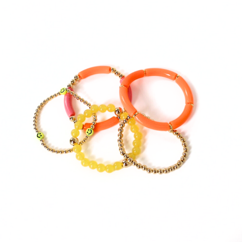 5-piece vibrant peach and yellow acrylic bracelet stack with 18k gold filled round beads. This set has a dainty gold beaded bracelet with cute yellow smiley face beads.