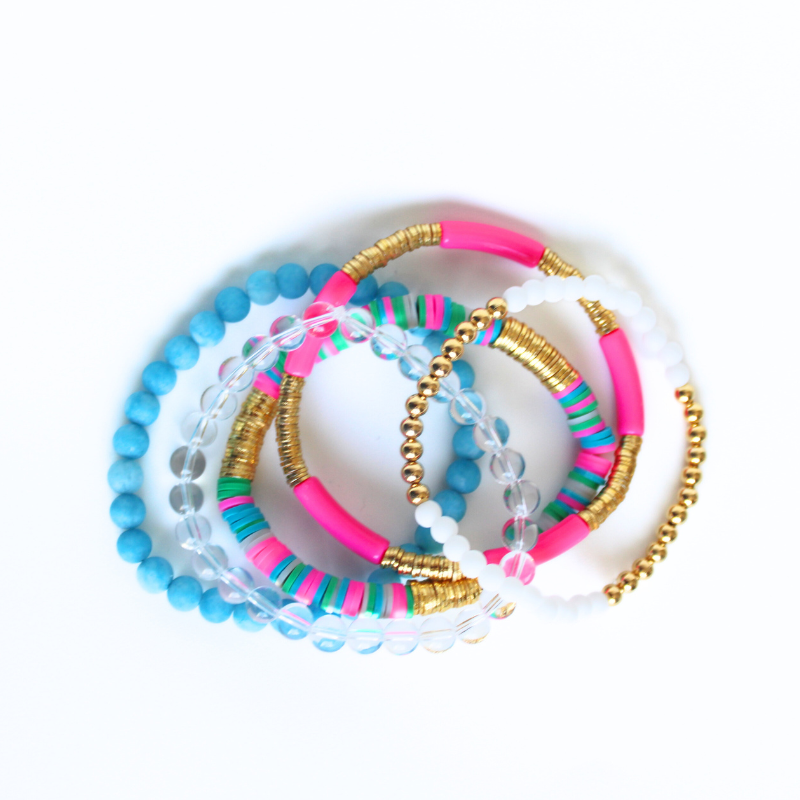 This 5-piece blue and pink beaded stretch bracelet set is the perfect statement piece. With its bold and bright colors, it is designed with 18K gold filled beads, clear round natural Brazilian beads and blue matte jade beads. The pink acrylic bangle and the pink and blue rainbow polymer clay beads add that pop of color.