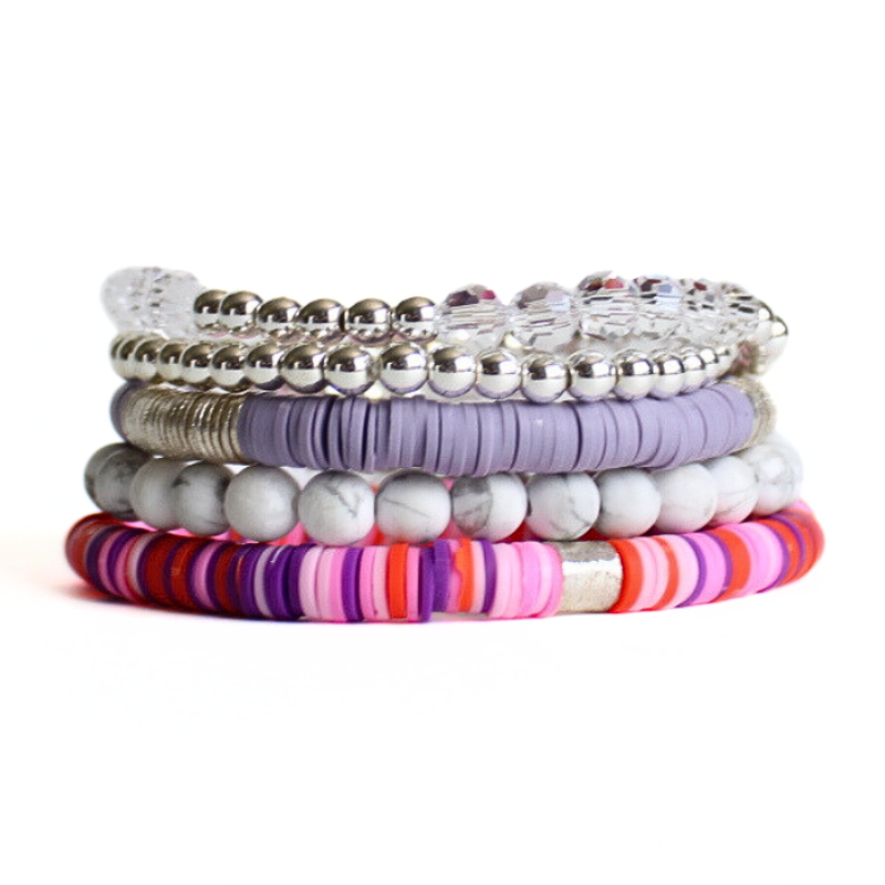 This 5-piece pink beaded stretch bracelet set is the perfect statement piece. With its bold and bright colors, it is designed with silver beads, clear glass beads and white howlite beads. The pink and purple rainbow polymer clay beads add that perfect pop of color.