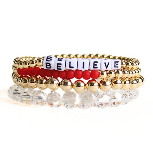 Bracelet set comes with four bracelets. One 4mm 18k gold filled beaded bracelet with customizable white letter beads with black lettering. One bracelet with 4mm 18k gold filled beaded bracelet with red matte glass seed beads. One 6mm 18k gold filled-waterproof beaded bracelet. One clear faceted glass beaded bracelet.