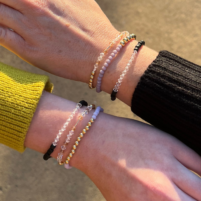2 models wearing black and gold morse code message bracelet. This set comes with 2 bracelets; 2 sets of 3.  One for you and one for your best friend