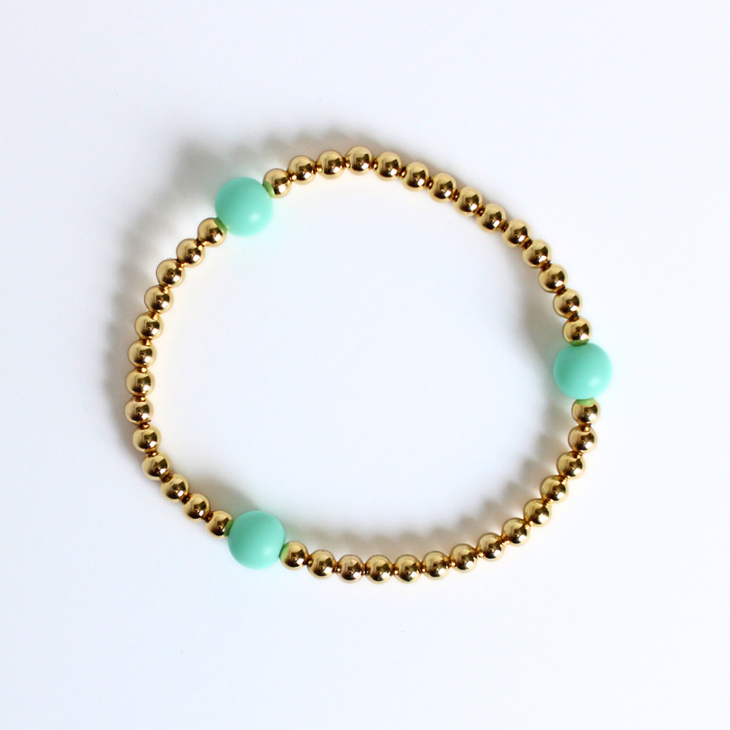 Dainty gold beaded stretch bracelet featuring matte green acrylic beads
