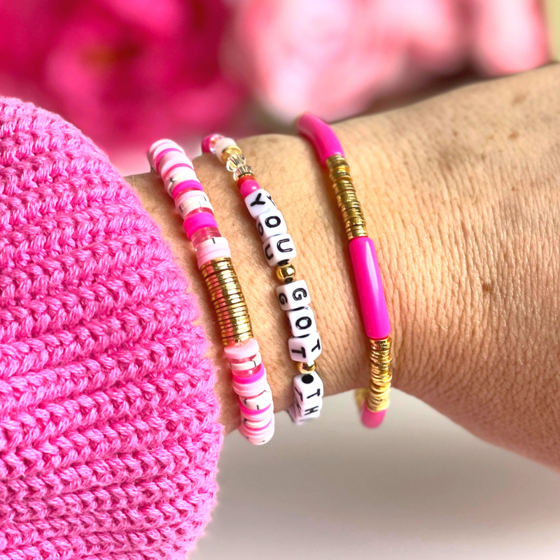 Pink beaded breast cancer awareness bracelet set. This very pink 3-piece bracelet set is curated with pink acrylic bangle, clear round quartz beads, pink beads and word beaded bracelet. Proceeds will be donated to the Susan G. Komen Foundation.